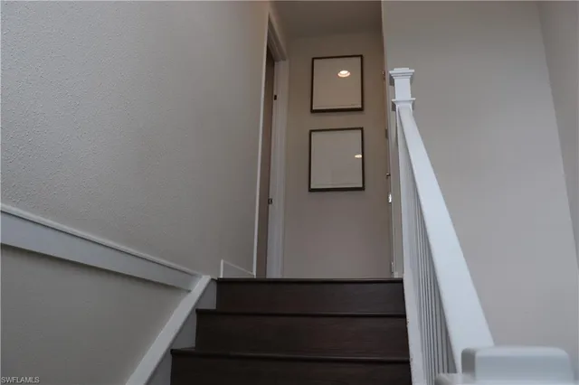 a view of staircase with railing and a window