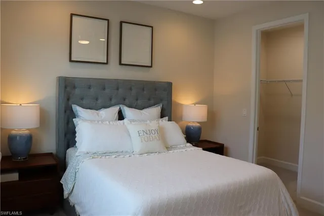 a bedroom with a bed and a flat tv screen on dresser