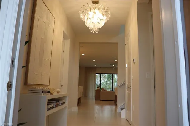 a view of a hallway with windows and chandelier