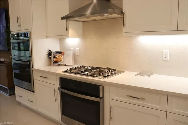 a white stove top oven sitting inside of a kitchen