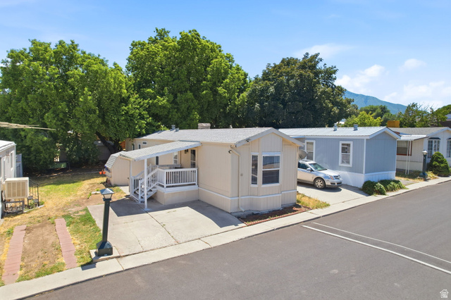 1525 South 400 East, Unit 13 Springville, UT 84663 - Photo 4 of 32 Single-story residence featuring a covered front porch with white railing, a bay window, and a paved driveway