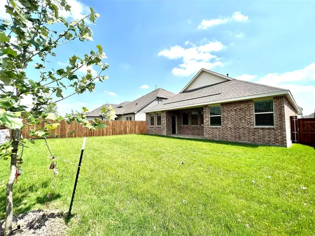a backyard of a house with table and chairs