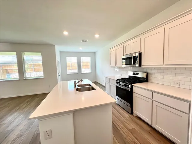 a kitchen with a stove a sink and a microwave