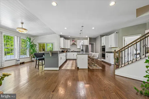 a dining room with furniture entryway and wooden floor