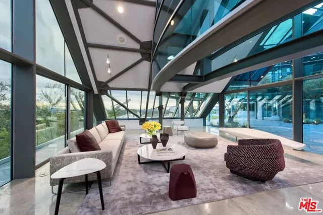 a living room with patio furniture and a floor to ceiling window