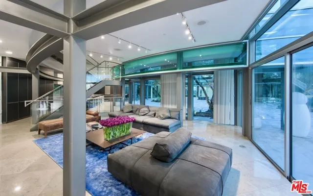 a living room with patio furniture and a floor to ceiling window