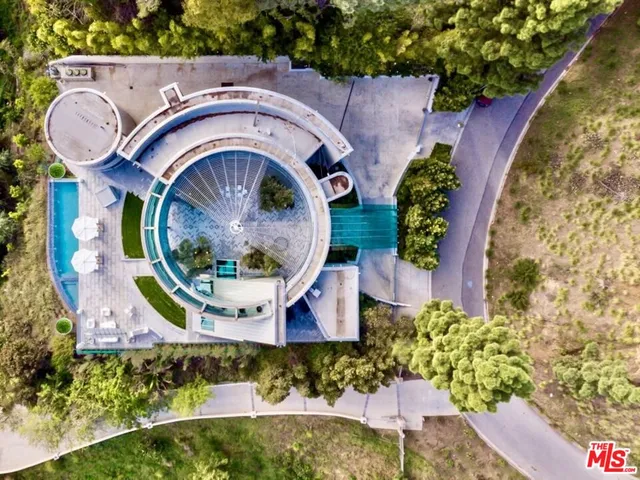 a view of a house with a small yard and large trees