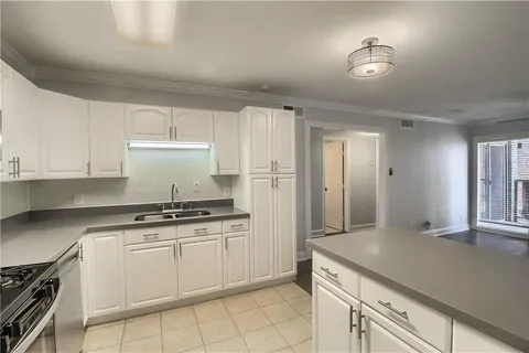 a kitchen with granite countertop white cabinets and white appliances