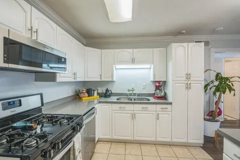 a kitchen with white cabinets and appliances