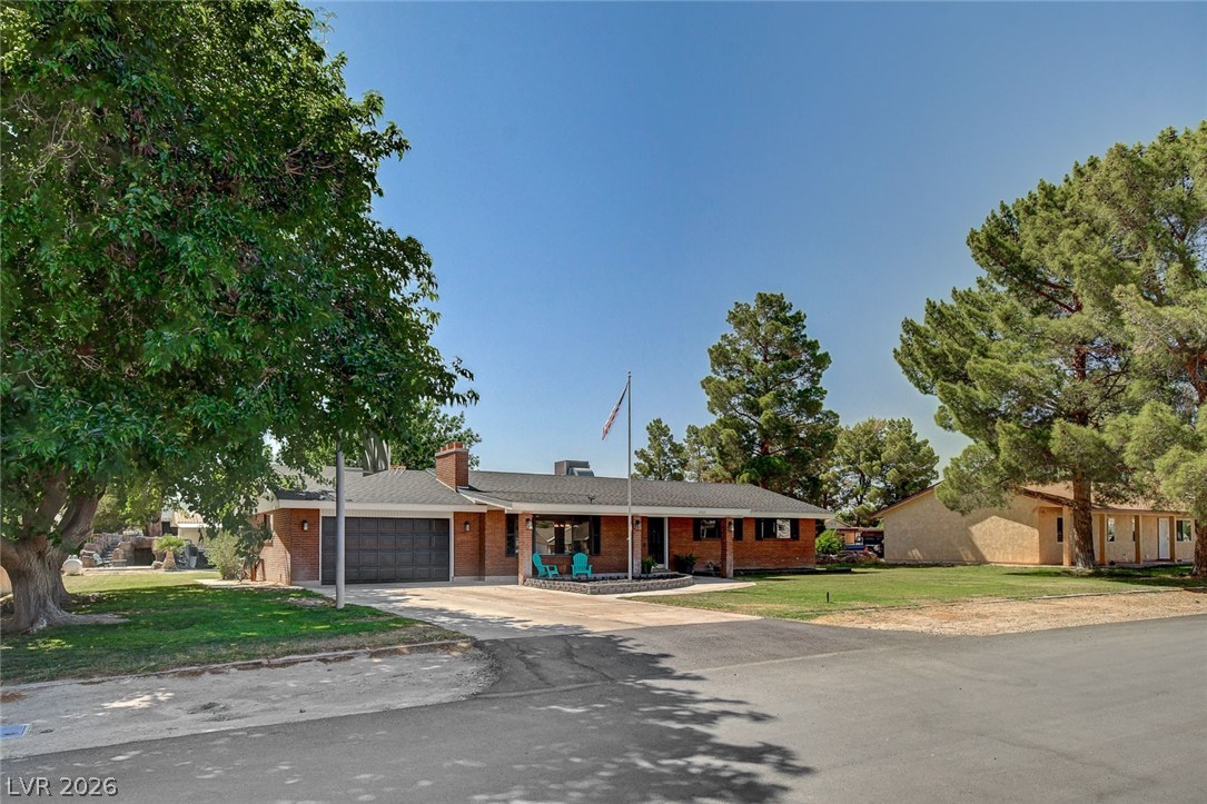 3765 Berkeley Street Logandale, NV 89021 - Photo 8 of 87 This classic brick residence features a welcoming facade with a well-maintained driveway and mature trees.