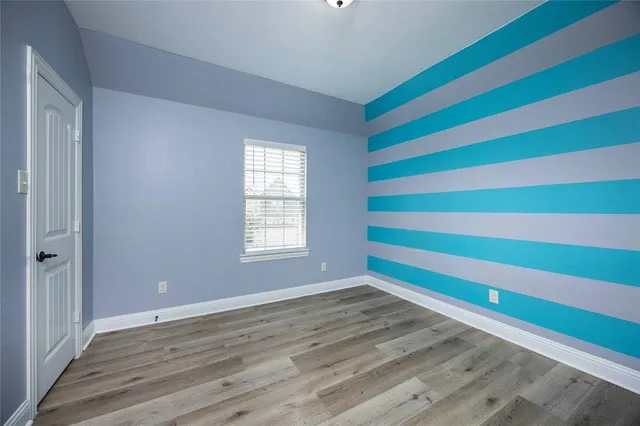 an empty room with wooden floor and closet