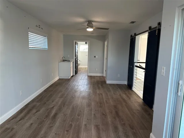 a view of empty room with wooden floor and window