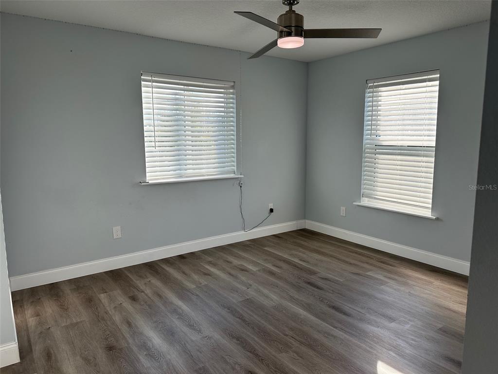 7119 Fair Lane Hudson, FL 34667 - Photo 17 of 32 a view of an empty room with wooden floor and a window