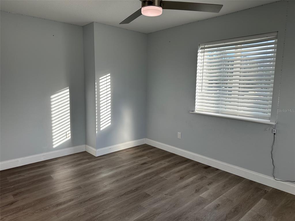 7119 Fair Lane Hudson, FL 34667 - Photo 18 of 32 a view of an empty room with wooden floor and a window