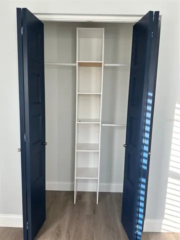 a view of walk in closet with empty racks