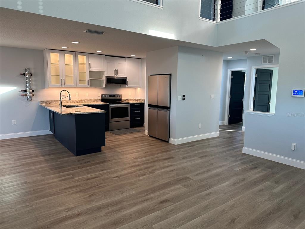 7119 Fair Lane Hudson, FL 34667 - Photo 5 of 32 a large kitchen with stainless steel appliances granite countertop a large counter top and wooden floors