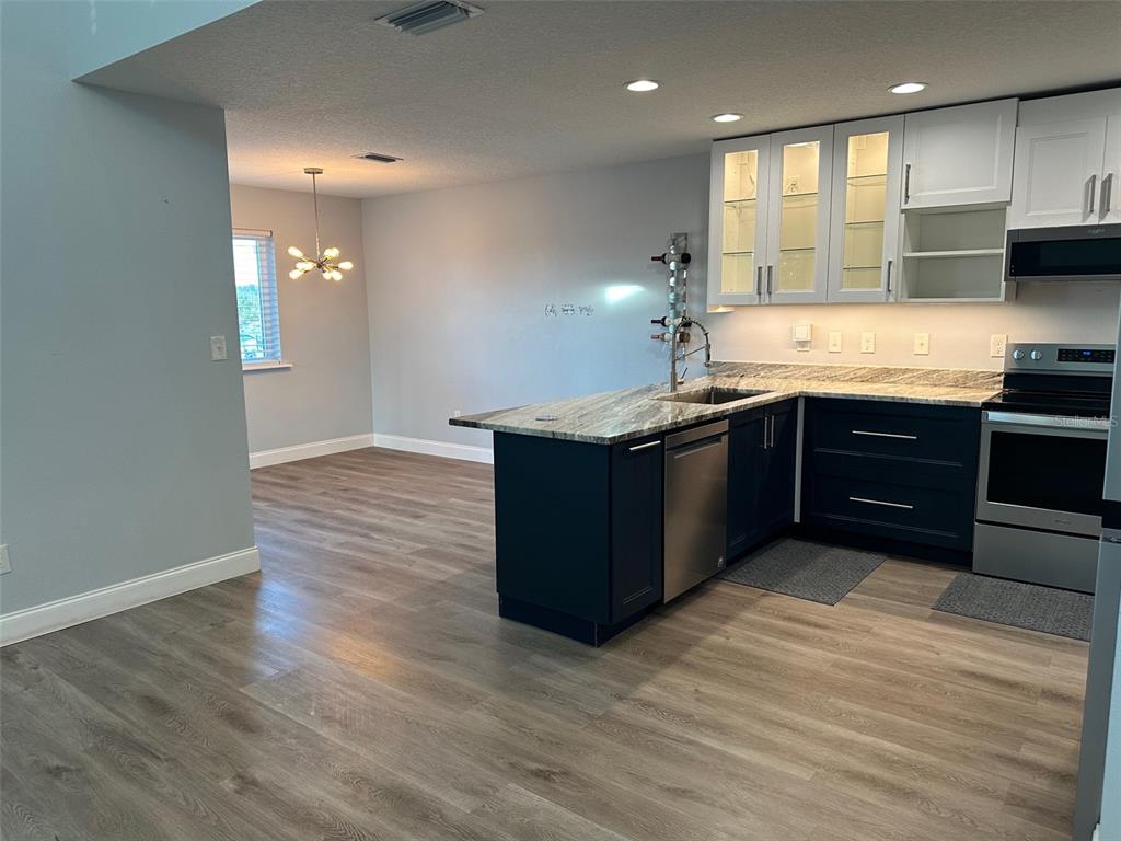 7119 Fair Lane Hudson, FL 34667 - Photo 8 of 32 a kitchen with stainless steel appliances granite countertop a sink counter space and cabinets