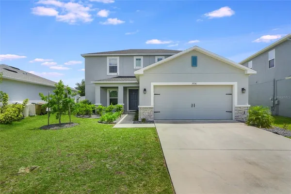 a front view of house with yard and green space