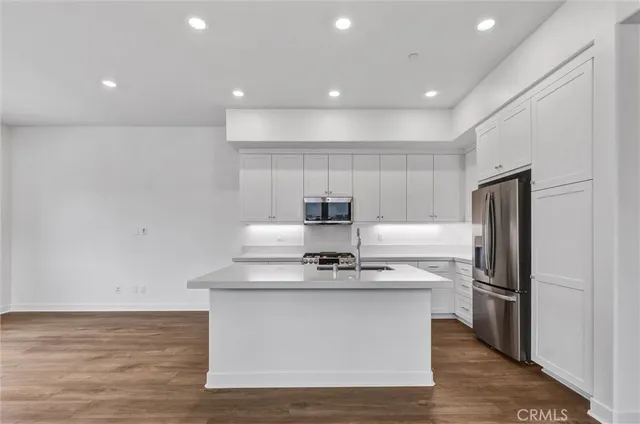 a kitchen with stainless steel appliances granite countertop a stove a sink and a refrigerator