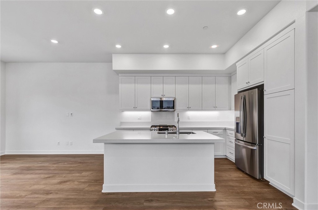 1808 Hollyleaf Terrace Montebello, CA 90640 - Photo 12 of 56 a kitchen with kitchen island stainless steel appliances a sink and a refrigerator