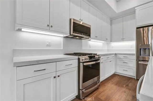 a kitchen with stainless steel appliances granite countertop a refrigerator and a stove