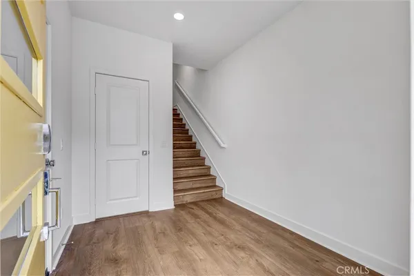 a view of a hallway with wooden floor and entryway