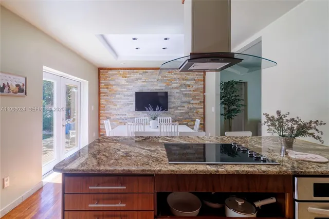 a kitchen view with granite countertop a sink and a stove
