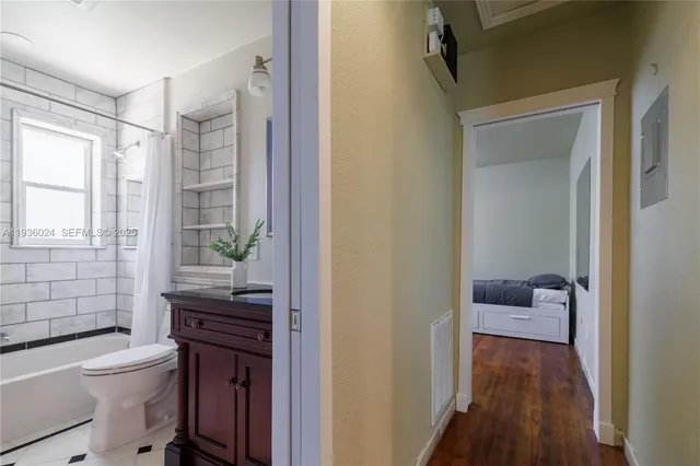 a bathroom with a granite countertop sink a toilet and shower