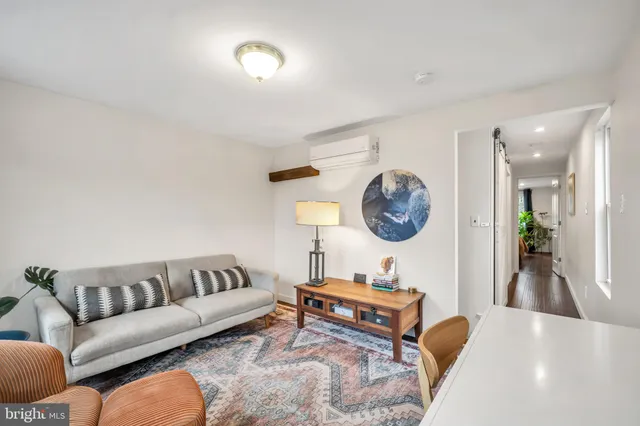 a living room with furniture a rug and a wall painting