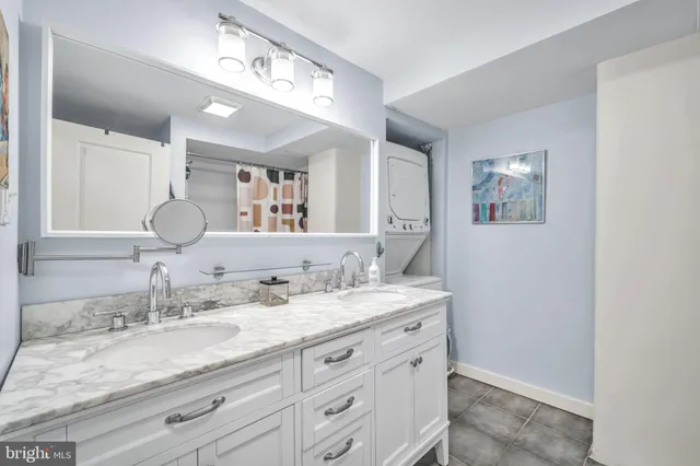 a bathroom with a granite countertop double vanity sink and a mirror