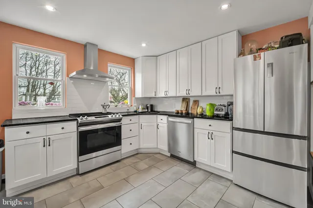 a kitchen with granite countertop white cabinets and white appliances