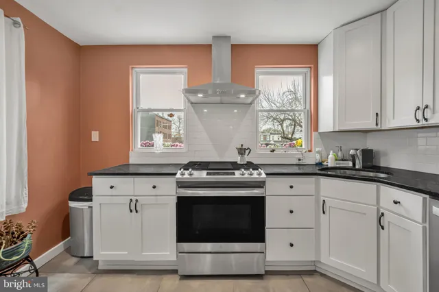 a kitchen with granite countertop white cabinets and white stainless steel appliances