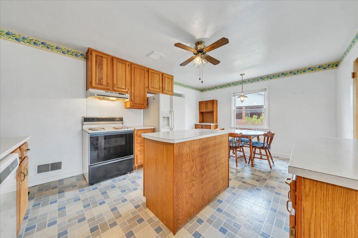 449 Cameron Drive Vinton, VA 24179 - Photo 14 of 39 a kitchen with stainless steel appliances granite countertop a stove top oven a sink a dining table and chairs with wooden floor