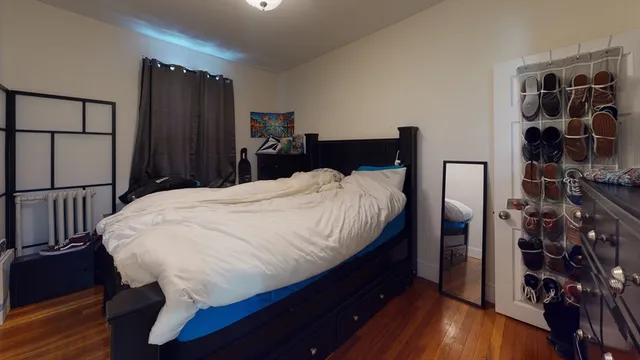 a bed sitting in a bedroom next to a cabinet
