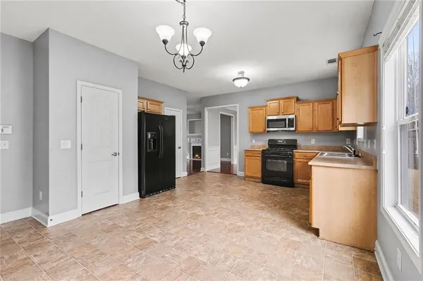 a large kitchen with a refrigerator a stove top oven a sink and dishwasher