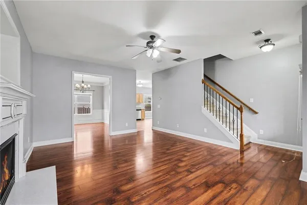 a view interior of a house with wooden floor a ceiling fan and windows