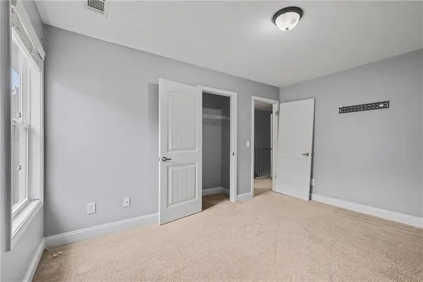 an empty room with closet and a window