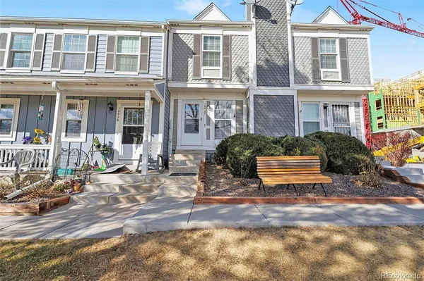 a view of a brick building with many windows and plants