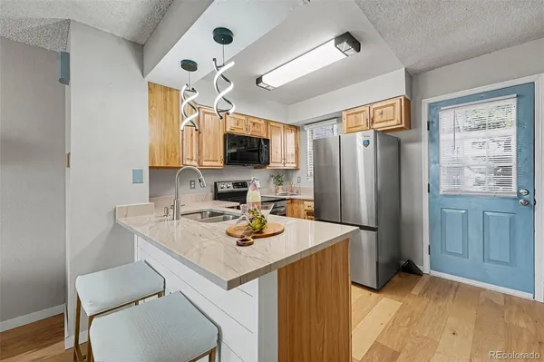 a kitchen with stainless steel appliances a stove refrigerator sink and cabinets