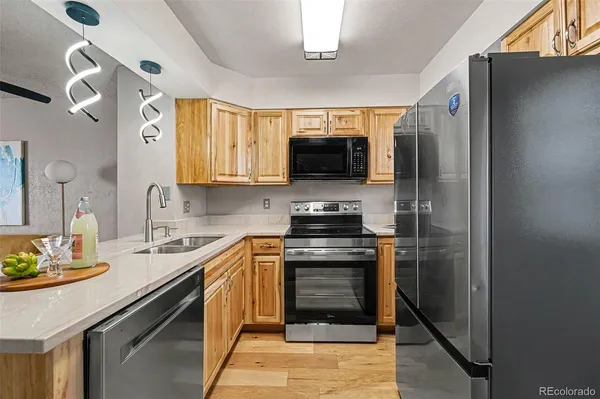 a kitchen with stainless steel appliances granite countertop a stove a sink and a refrigerator