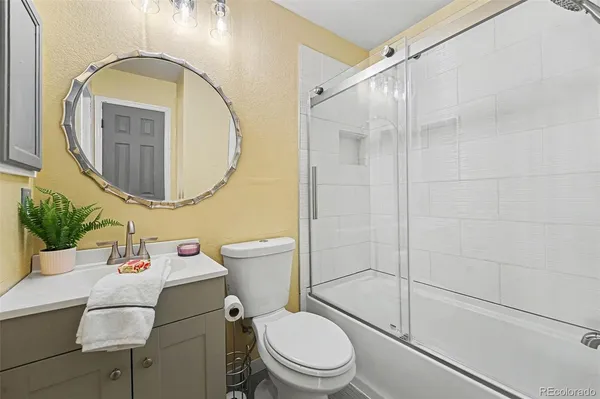 a white toilet sitting next to a bathroom sink and a mirror