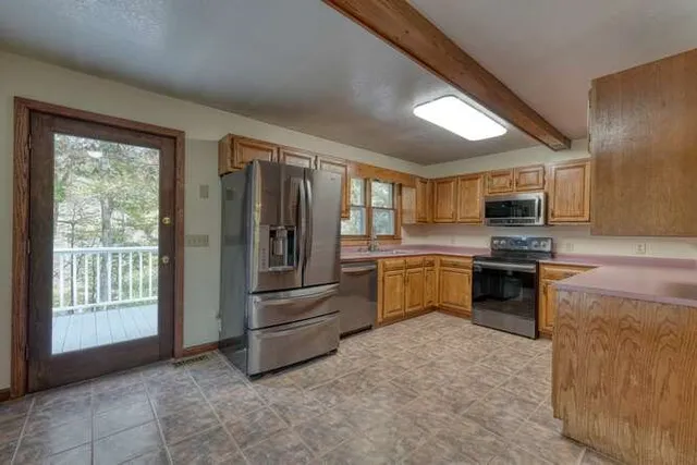 a view of an empty room with a kitchen