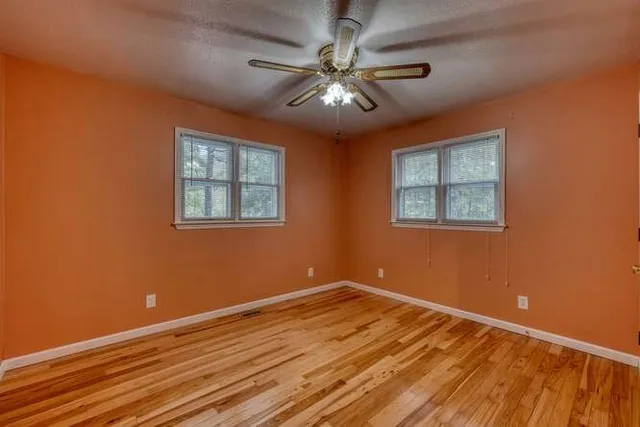an empty room with a ceiling fan and a fan