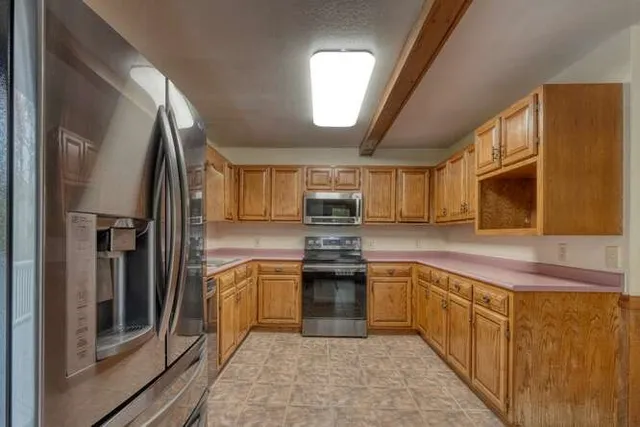 a view of a house with a yard and large tree