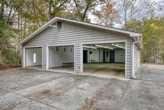 a backyard of a house with large trees and wooden fence