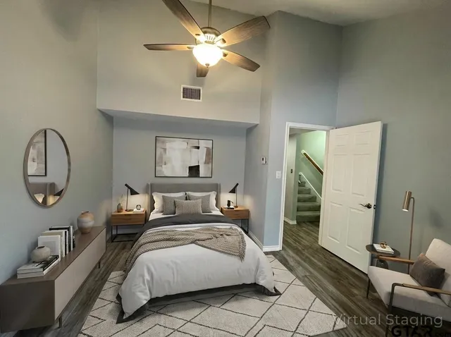 a spacious bedroom with a bed a couch and a chandelier