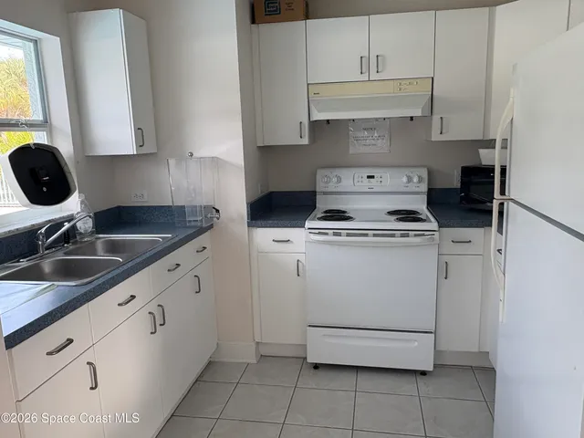 a kitchen with cabinets appliances a sink and a stove