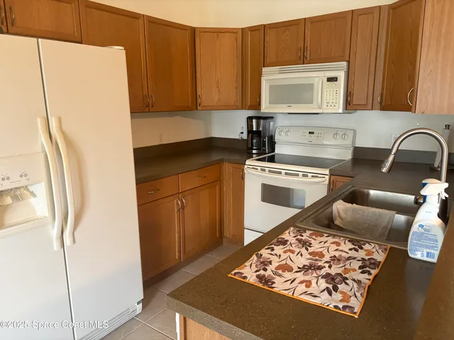 a kitchen with stainless steel appliances granite countertop a refrigerator sink and stove