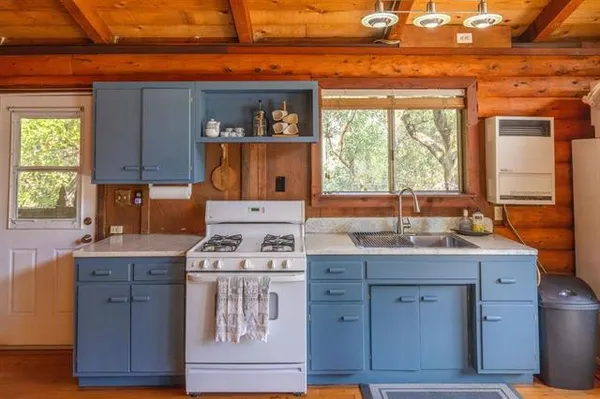 a kitchen with a stove a sink and a window