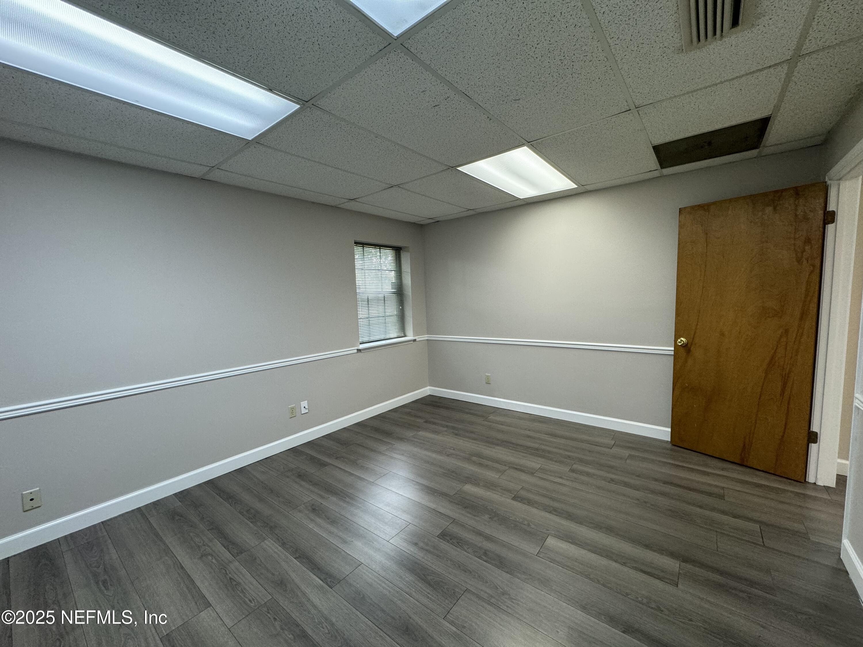 3938 Sunbeam Road Jacksonville, FL 32257 - Photo 14 of 28 an empty room with wooden floor and windows